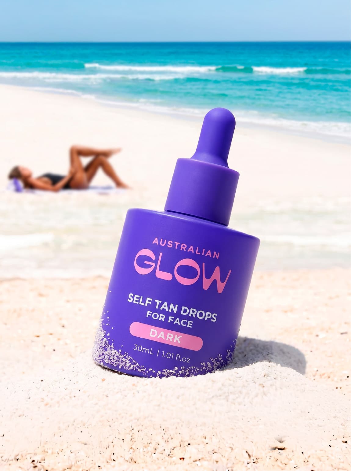 Curly-haired model on lavender backdrop holding the drops bottle